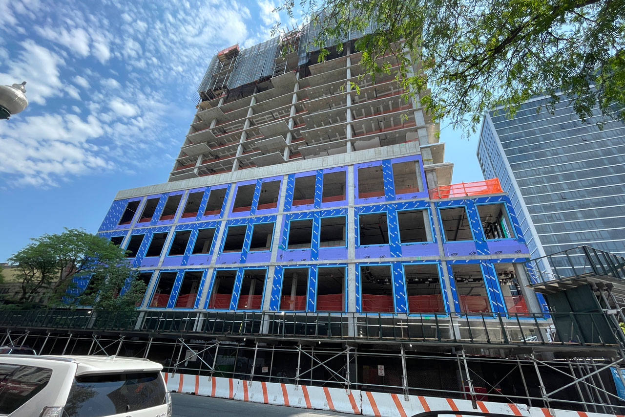 A cityscape with a new building under construction, highlighting cranes and construction equipment in an urban environment.