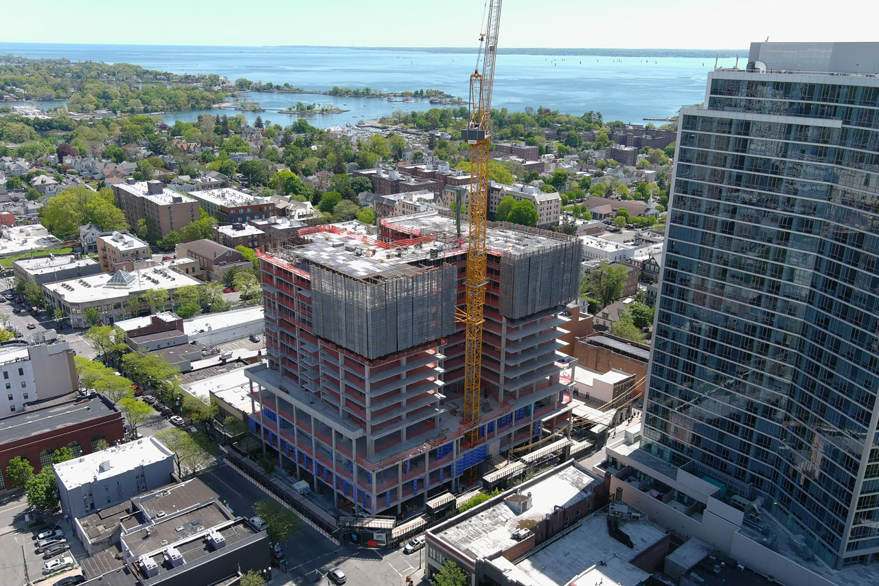 Aerial view of a construction site showcasing a building in progress, with cranes and scaffolding visible from above.